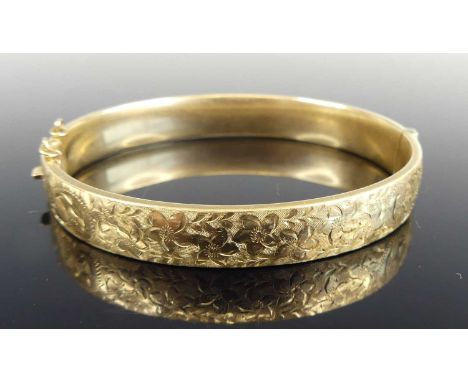 A Victorian style 9ct gold hinged bangle, one side with scroll leaf engraved decoration, London 1973, dia.6.5cm, 17.6gSponsor