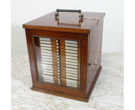 A circa 1900 mahogany collectors specimen cabinet, having a glazed door concealing 21 numbered drawers, each containing micro
