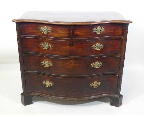 A George III mahogany chest, of serpentine outline, having two short and three long graduated drawers each with replacement p