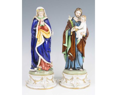 A pair of late 19th century German porcelain figures of the Virgin Mary and Joseph, probably Rauenstein, Mary modelled in sta