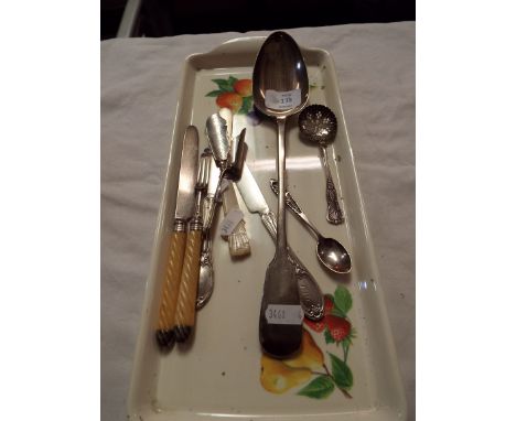 A silver basting spoon together with a selection of other cutlery