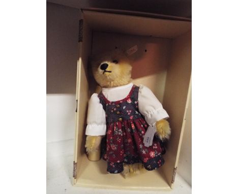 A boxed Steiff Austria 32 Bear having blond mohair fitted with a squeaker and dressed in traditional dirndl theme, nose and p