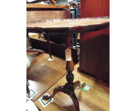 A mahogany pie-crust top side table raised on a tripod base