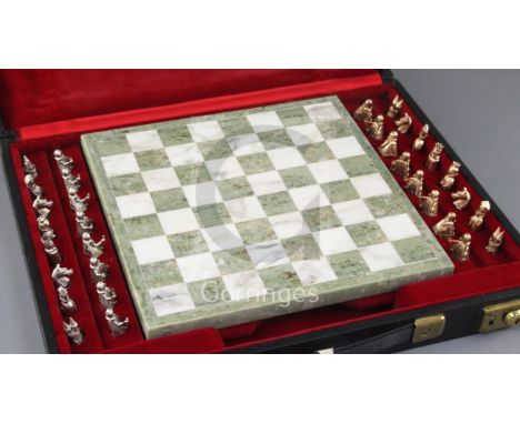 A cased 1960's chess set with a white and green marble chess board and thirty two 9ct gold chess pieces, in white and yellow 