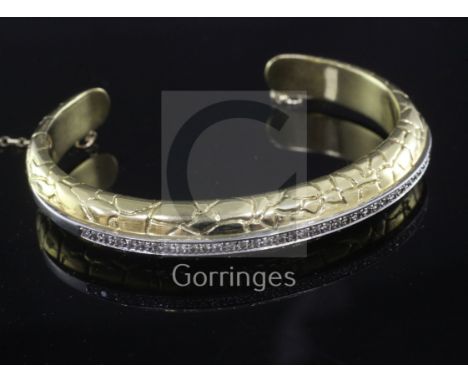 A 1980's Italian Gucci 18ct gold and diamond set 'crocodillo' open bangle, with central row of thirty five small round cut di