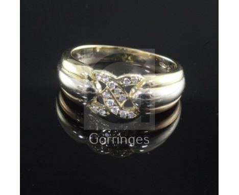 A 1980's Cartier three colour gold and diamond set ring, with pierced central motif and numbered 589486, with Cartier certifi