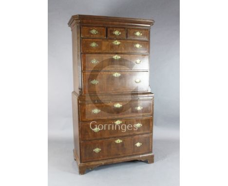 A George II walnut chest on chest, fitted three short, three graduated drawers over a slide and three further graduated drawe