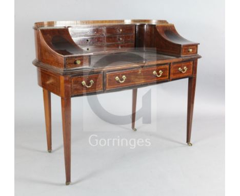 An Edwardian satinwood banded mahogany Carlton House desk, the raised superstructure fitted with eight drawers, corner cupboa