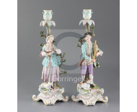 A pair of Meissen candlestick figures, late 19th century, each modelled as a musical shepherd and shepherdess, on scrollwork 