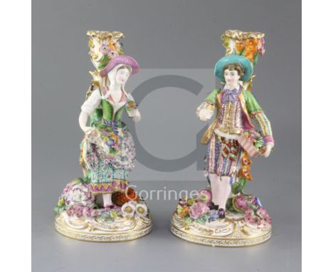 A pair of Minton candlestick figures, c.1835-36, modelled as male and female flower sellers, with floral encrusted stems and 