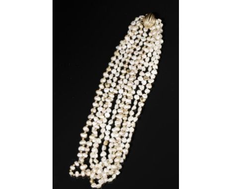 A BAROQUE PEARL AND YELLOW GOLD NECKLACE with four strands, the inner two with gold bead spacers and the outer three with irr