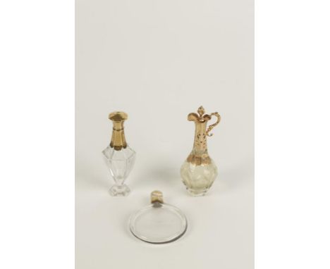 A CONTINENTAL CLEAR GLASS AND YELLOW METAL MOUNTED SCENT BOTTLE, the yellow metal and enamel screw lid decorated with leaf sw