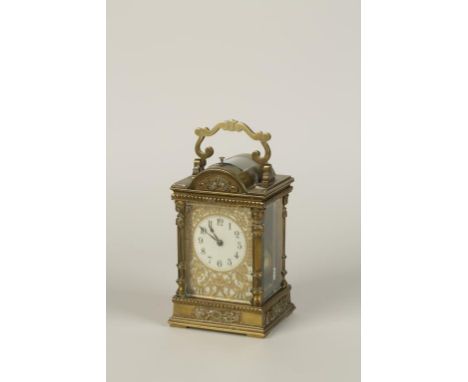 A GILT METAL CARRIAGE CLOCK the ivory coloured dial with an engraved and foliate pierced overlay, the repeating movement with