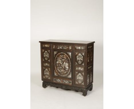 A CHINESE HARDWOOD SIDE CABINET fitted with three short frieze drawers above a central cupboard door, a short drawer beneath,