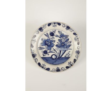 A DELFTWARE TIN-GLAZED POTTERY CHARGER painted in blue with floral decoration within a patterned blue border, 18th century, 1