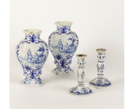 A PAIR OF DELFTWARE TIN GLAZED VASES painted in blue with a young man serenading a lady with a church in the distance, within