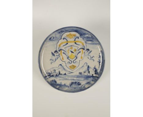 AN ITALIAN "SAVONA" BLUE AND WHITE MAIOLICA ARMORIAL PLATE painted with a bold coat of arms, enriched in yellow, above a moun