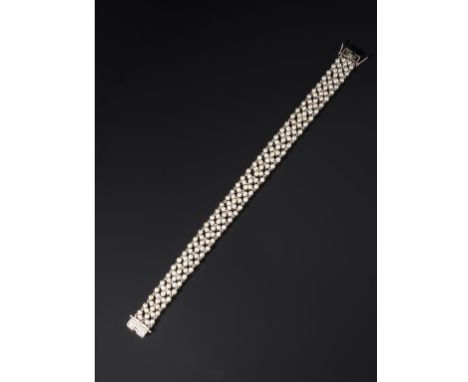 AN ART DECO SEED PEARL AND DIAMOND BRACELET with a geometric panel of pearls and a rectangular clasp set with three lines of 