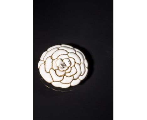 A CARTIER WHITE ENAMEL AND DIAMOND FLOWER BROOCH in the form of a chrysanthemum with petals radiating from a central baguette