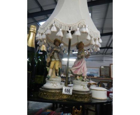 A figural lamp featuring a boy and girl with shade