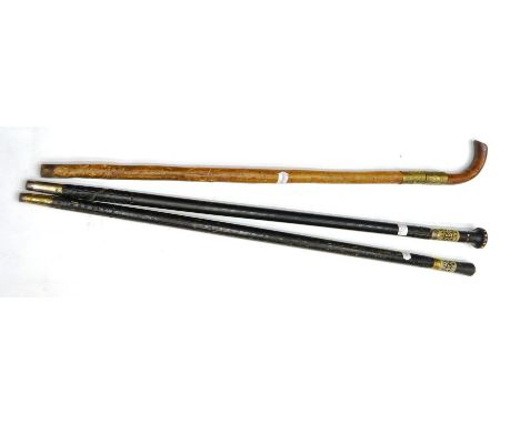 An Indian Swordstick, with 70cm square section steel blade, the curved wood grip and haft with brass mounts; two Indian Eboni