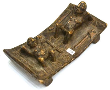 An African Hardwood Altar Piece, possibly Cameroon, carved as two women in crab-like positions on a curved rectangular plinth