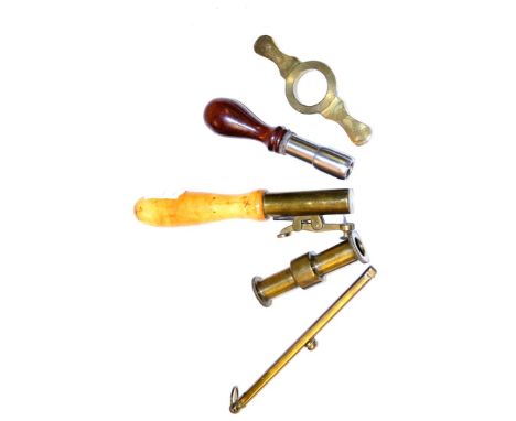 A Brass Double Bar Percussion Cap Dispenser, with visible steel spring and brass suspension ring; a 20 Bore Cartridge Case Tr