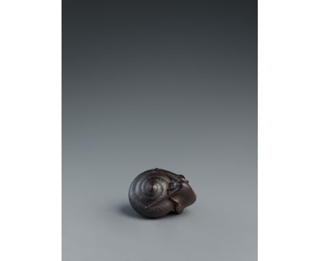 Netsuke einer Schnecke. Holz, sehr dunkel gebeizt. Nagoya. Mitte 19. Jh.Sign. in zwei versetzt angeordneten Kartuschen kaum m
