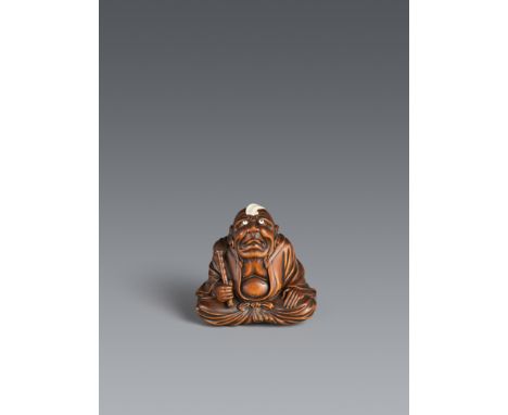 Okimono-Netsuke des Daruma beim kamifuki-Spiel. Buchsbaum. 2. Hälfte 19. Jh.Sign. auf Elfenbeinplättchen: RyūkeiMit untergesc