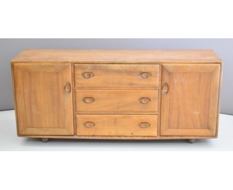 Ercol mid century modern / retro light elm sideboard with an arrangement of two cupboards either side of three drawers, W155 