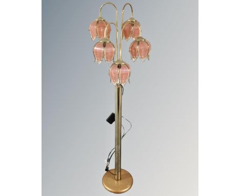 A brass five-way floor lamp with glass shades in the form of flower heads 