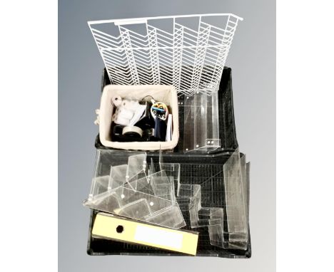 Two crates containing clear perspex display stands together with a metal wall rack, caddy containing cellotape dispenser, pen