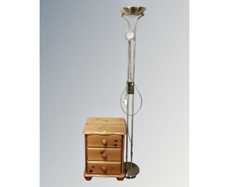 A pine three drawer bedside chest together with a contemporary floor lamp in a brass finish 