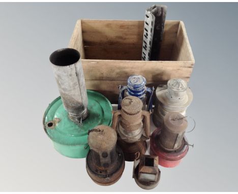 A vintage pine crate containing oil lamp, greenhouse heater, ships lamp