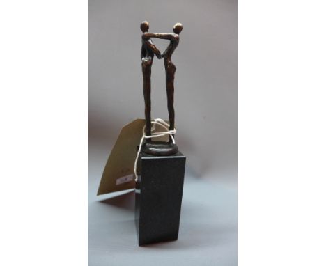 After Alberto Giacometti, a bronze figural study of two men shaking hands, raised on faux marble base. H. 19cm