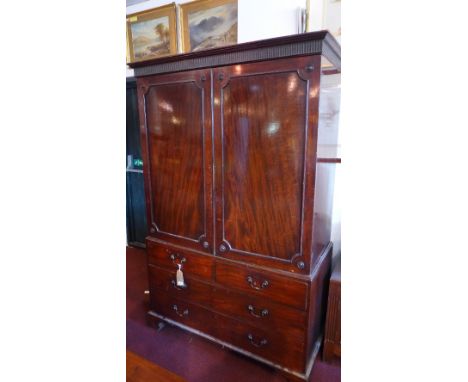 A Georgian mahogany linen press having two doors above two short and two long drawers raised on carved bracket feet, H:199cm 