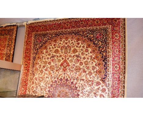 A Keshan style carpet with central floral medallion on a beige ground contained by borders. 230cm x 160cm 