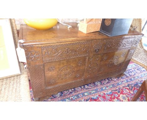 An 18th Century Dutch oak trunk, the front with carved floral decoration, dated 1781, raised on bracket feet having carrying 