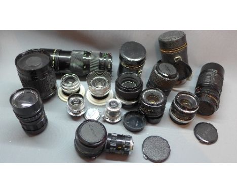 A collection of camera lenses including an Ernst Leitz, a Lecia lens, Schnieder lens and a quantity of Canon lenses.  