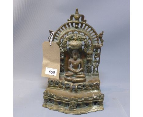 An Oriental bronze buddha, seated beneath an ornamental arch on a stepped base, H. 31cm