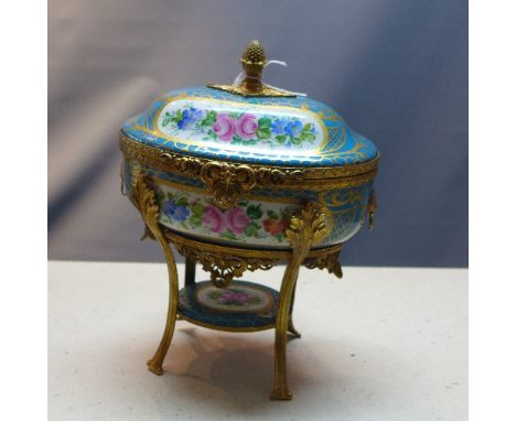 A Limoges French porcelain trinket box with hand painted floral panels on a turquoise blue ground with gilt highlights having