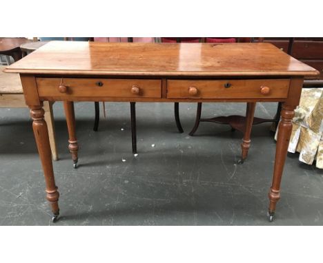 An early Victorian light mahogany desk, top with moulded edge, over two frieze drawers on ballister turned legs and brass cas