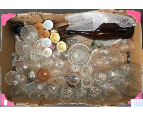 A box of ceramics and glass to include a number of vintage branded bottles, egg cups, drinking glasses, etc 