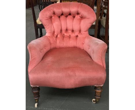 A Victorian button back low armchair, on turned legs and ceramic casters 