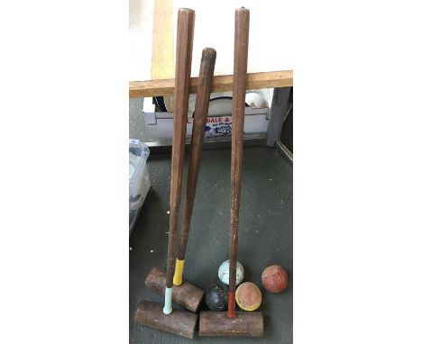 Three vintage croquet mallets and four wooden balls 