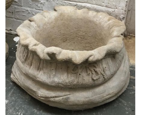 A large composite stone sack shaped planter 