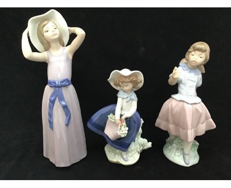 Two Lladro figures of girls 'Trying on a Straw Hat' no. 5011, 27cm high, 'Pretty Pickings' no. 5222 and a Nao figure of a gir