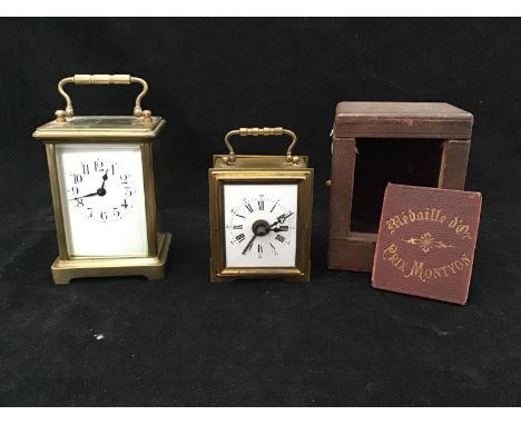 A French brass carriage clock, with exposed platform escapement, the white enamel dial with Arabic numerals denoting hours, r