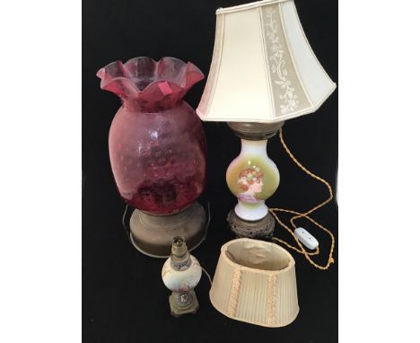 A large cranberry glass pineapple shaped oil lamp, lacking funnel, 49cm high, together with two porcelain and gilt metal tabl