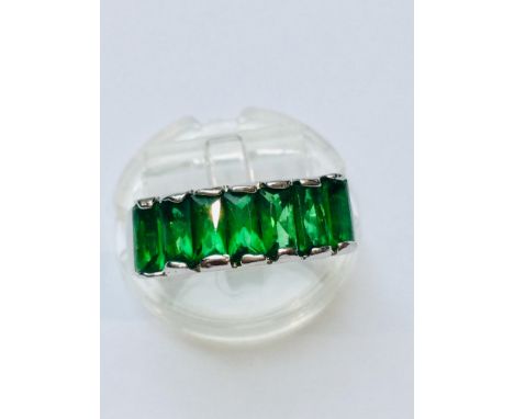 A ladys 18ct white gold-plated dress ring set with seven rectangular shaped green stones. Finger size N. Together with an 18c